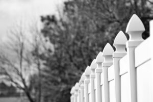 Gray Scale Photo of White Fence